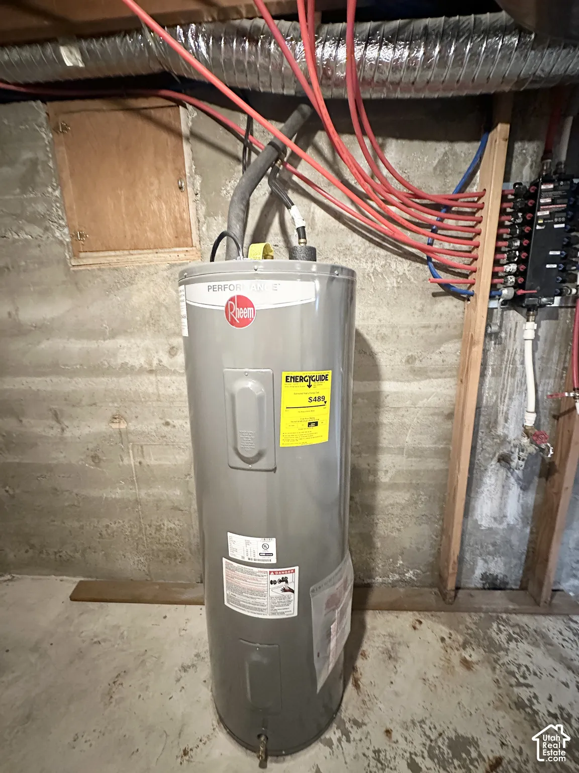 Hot water heater with an energy guide label, accompanied by PEX plumbing and ductwork