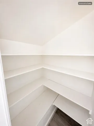Spacious walk-in closet featuring multiple built-in shelving units with clean lines and generous storage capacity