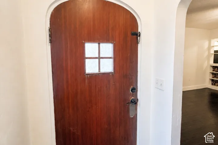Arched doorway featuring a wood-finish door with frosted glass insert
