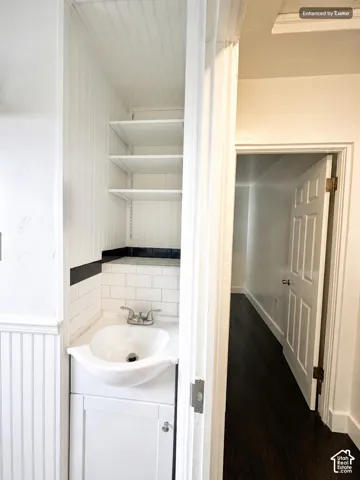 Compact vanity with an integrated sink, white subway tile backsplash, and beadboard paneling