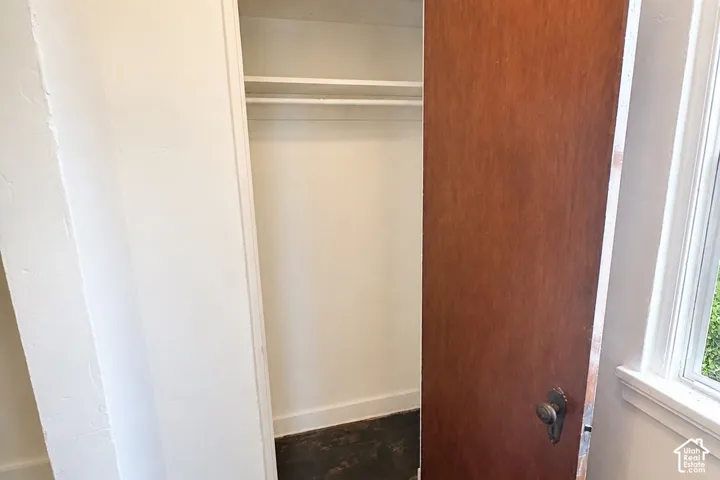 Closet with a single hanging rod, upper shelf, wood-finish door, and traditional door hardware