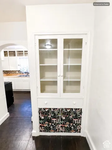 Built-in cabinetry featuring glass-front upper doors, a central drawer, and lower cabinet storage