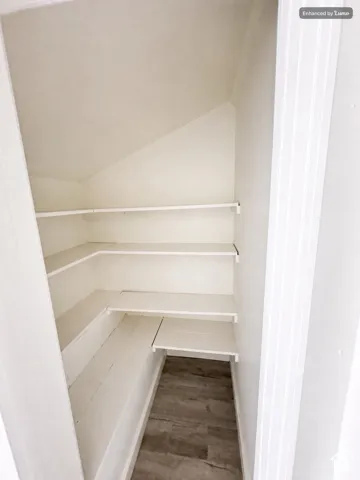 Built-in shelving with multiple levels, painted white finish, and wood-finish flooring