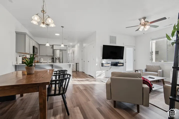 Open-concept living area featuring wood-finish flooring, recessed lighting, a ceiling fan, and white countertops