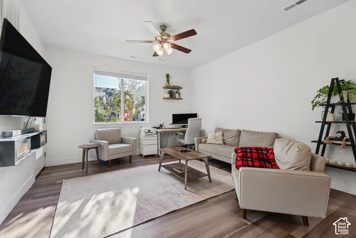 Wood-finish flooring, recessed lighting, and a ceiling fan with integrated lighting
