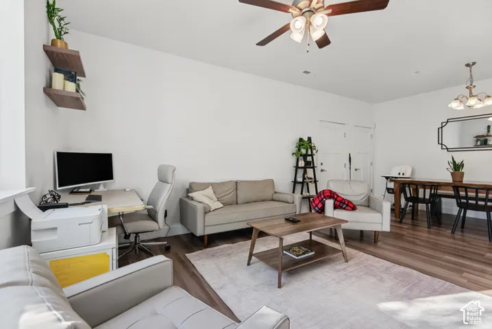 Open-concept living area with wood-finish flooring, recessed lighting, and a ceiling fan