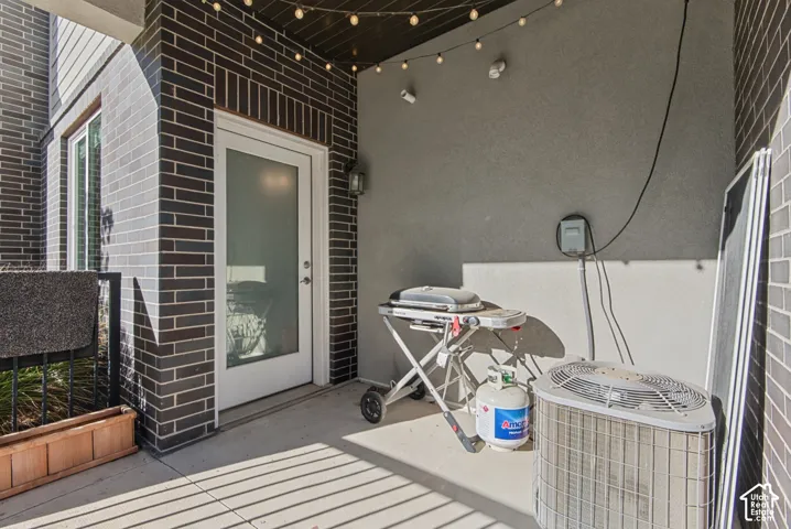 Patio area featuring dark brick facade, concrete flooring, and an exterior door with a frosted glass panel