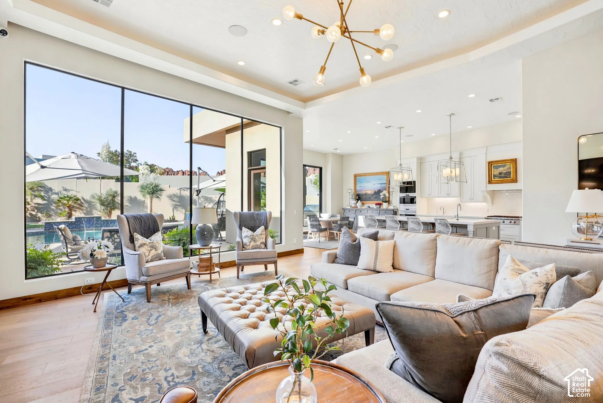 Expansive living area with high ceilings, recessed lighting, and a modern sputnik chandelier