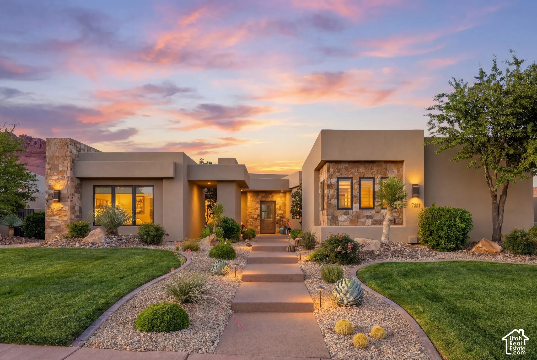 Contemporary stucco exterior with stone accents and exterior wall lighting