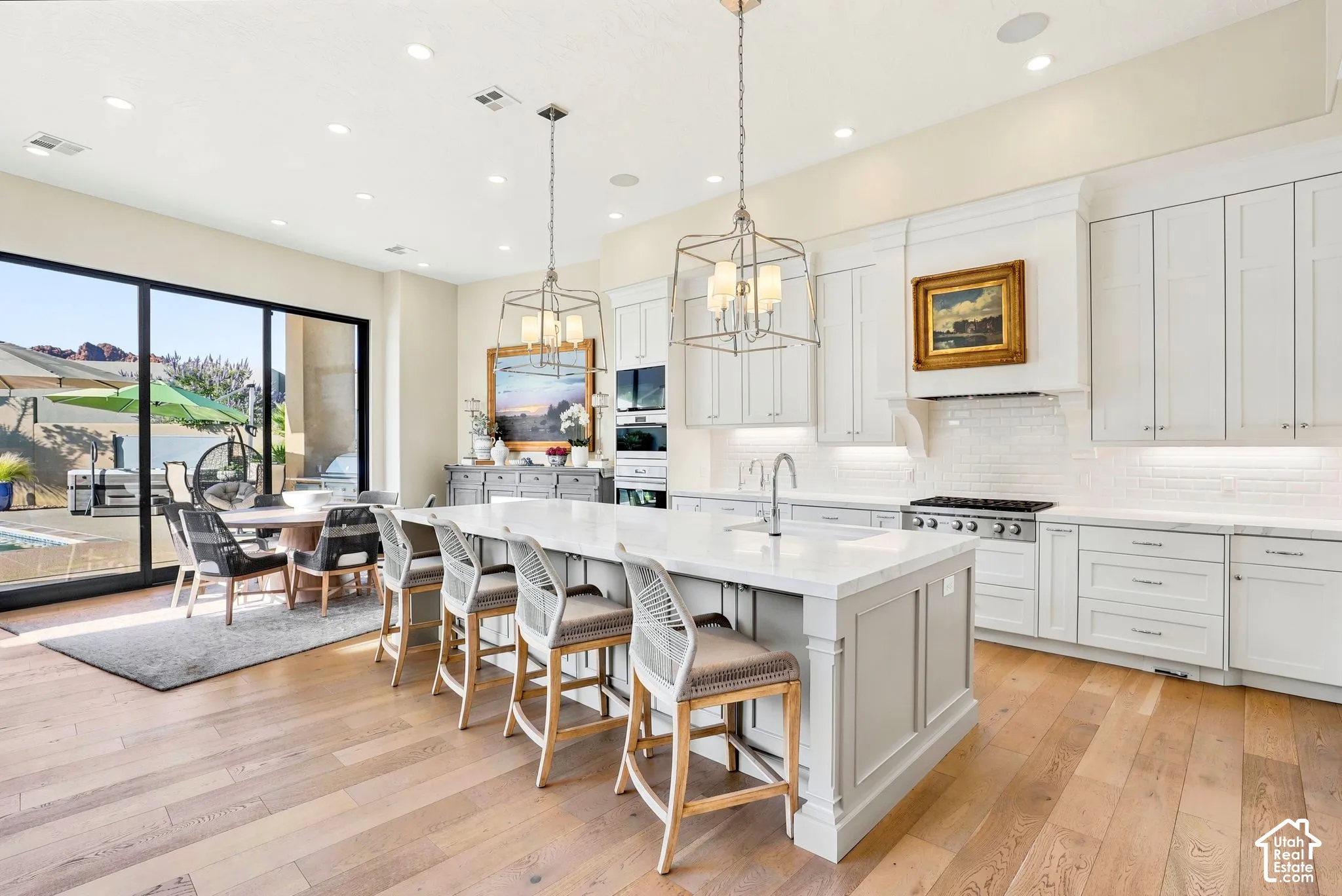 Gourmet kitchen with wood-finish flooring, a large center island, and white shaker cabinetry