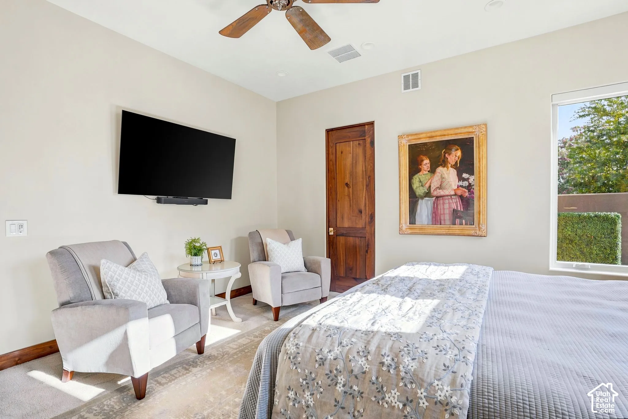 Ceiling fan with wood-finish blades, recessed lighting, and a window with exterior shrubbery