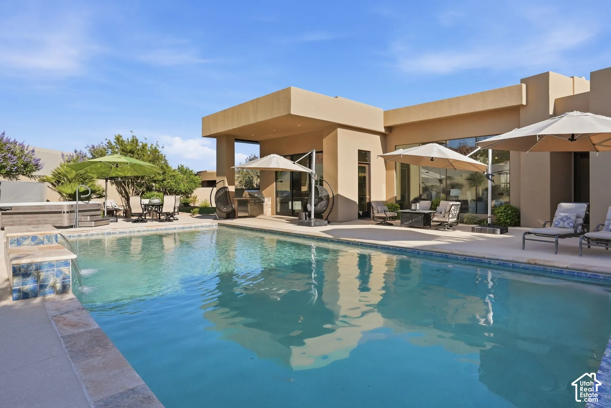 Expansive swimming pool with integrated spa and tiled accents, surrounded by a paved patio