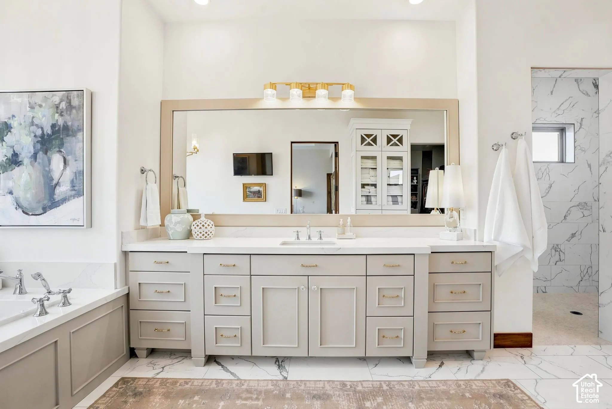 Dual vanity with light gray cabinetry, a single basin, and a framed mirror