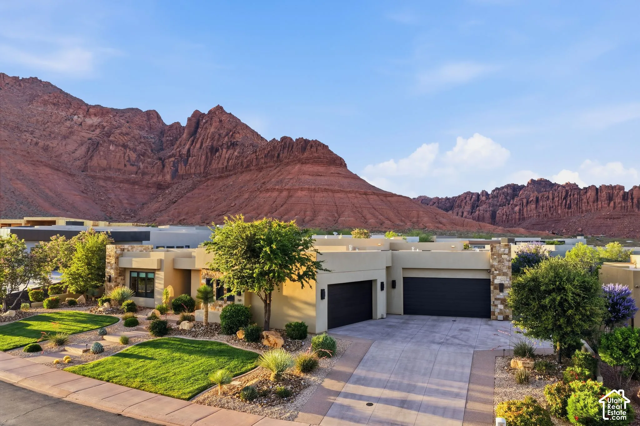 Contemporary desert architecture featuring a stucco exterior and stone accents