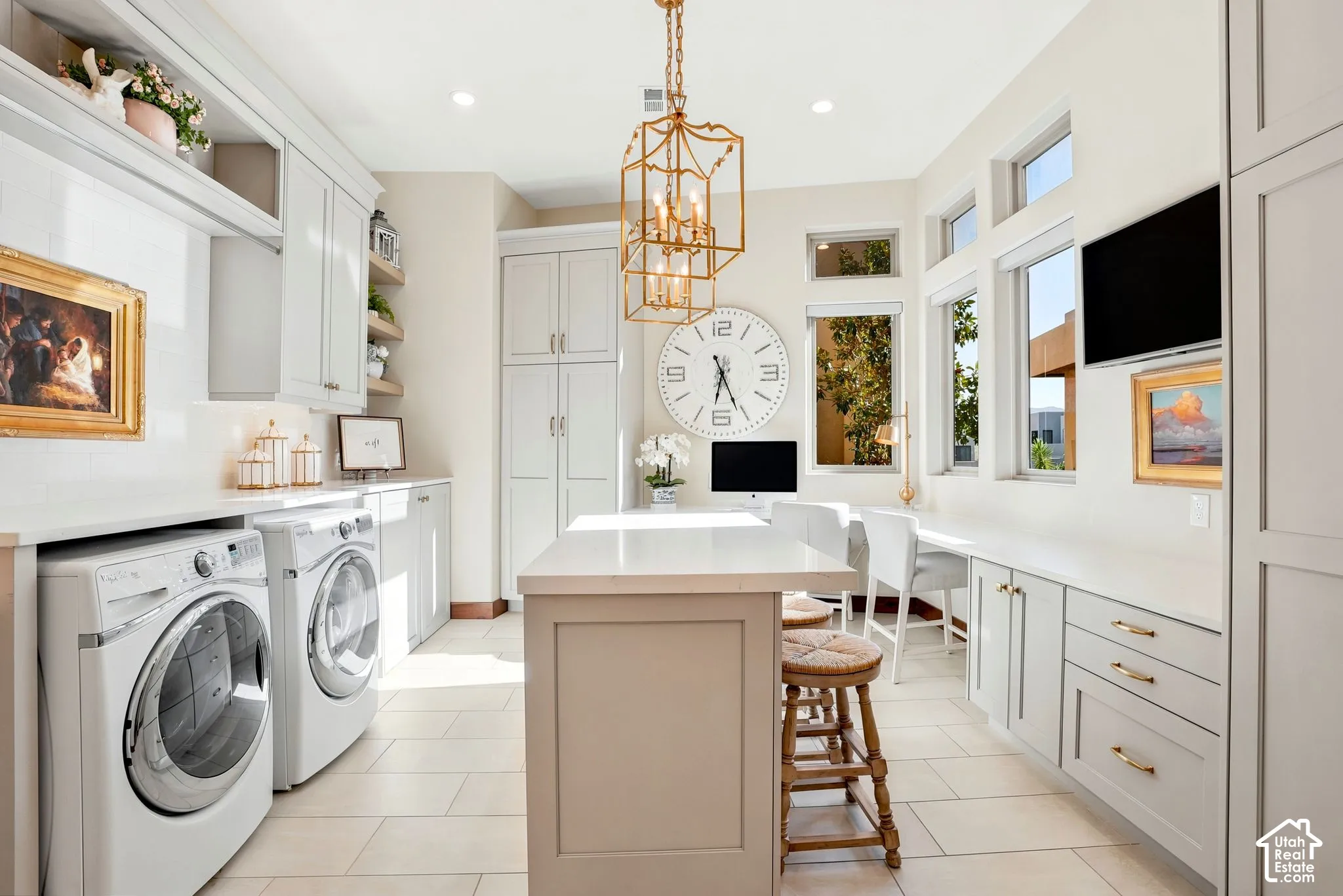 Built-in cabinetry with integrated appliances, transom and picture windows, a central island with countertop space, and tile flooring