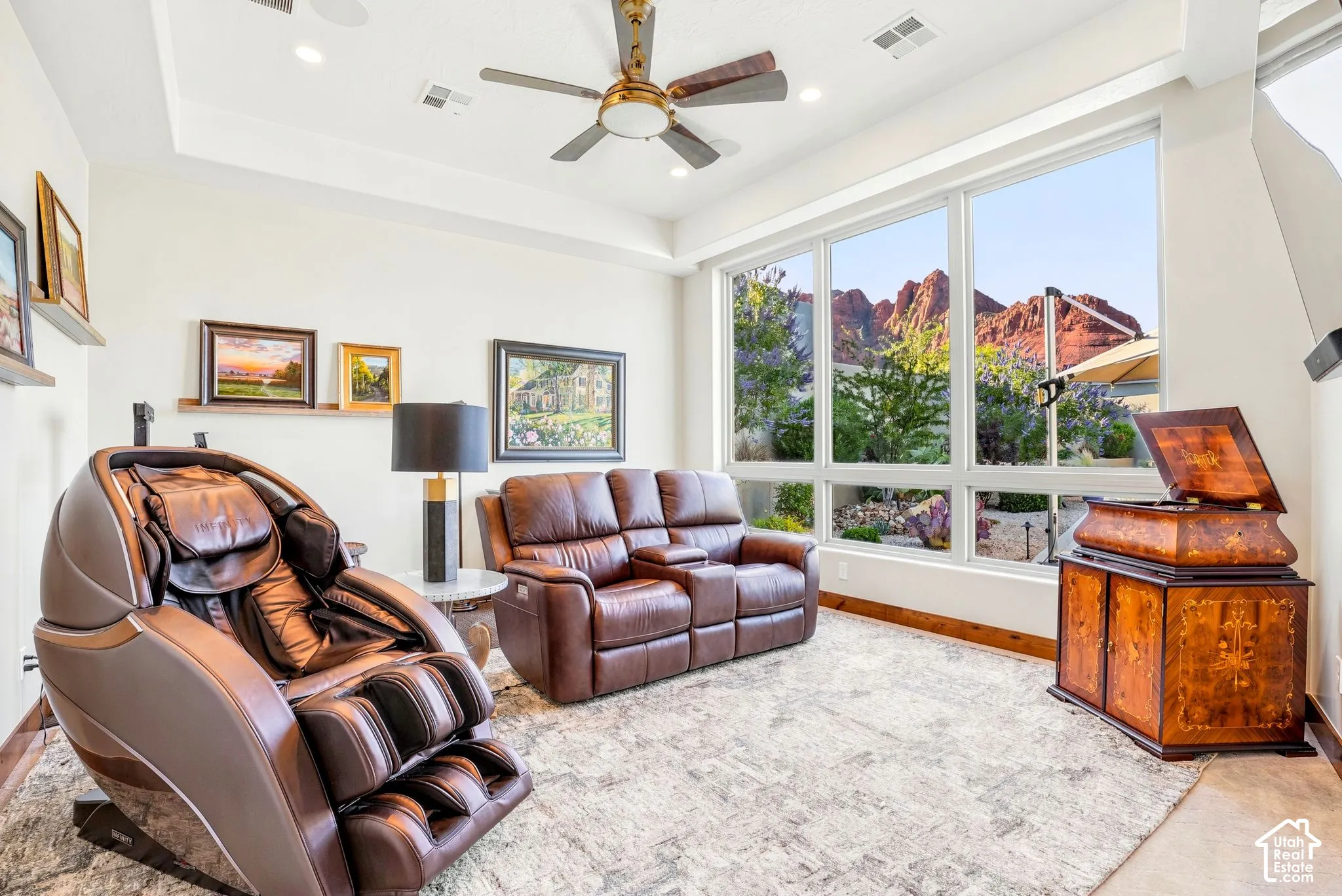 Tray ceiling with recessed lighting and a ceiling fan, expansive window wall, wood-finish flooring, and a decorative wall shelf