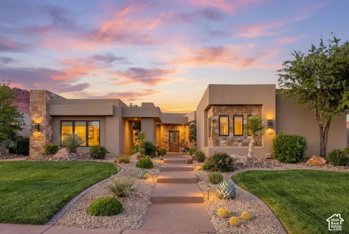 Contemporary stucco exterior with stone accents and exterior wall lighting