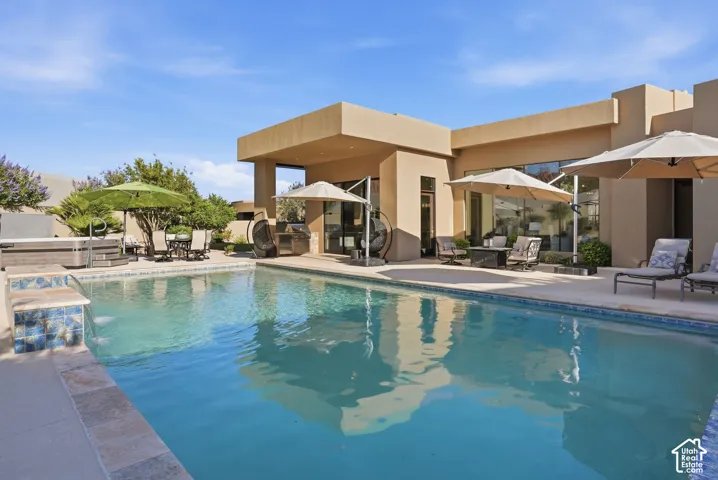 Expansive swimming pool with integrated spa and tiled accents, surrounded by a paved patio