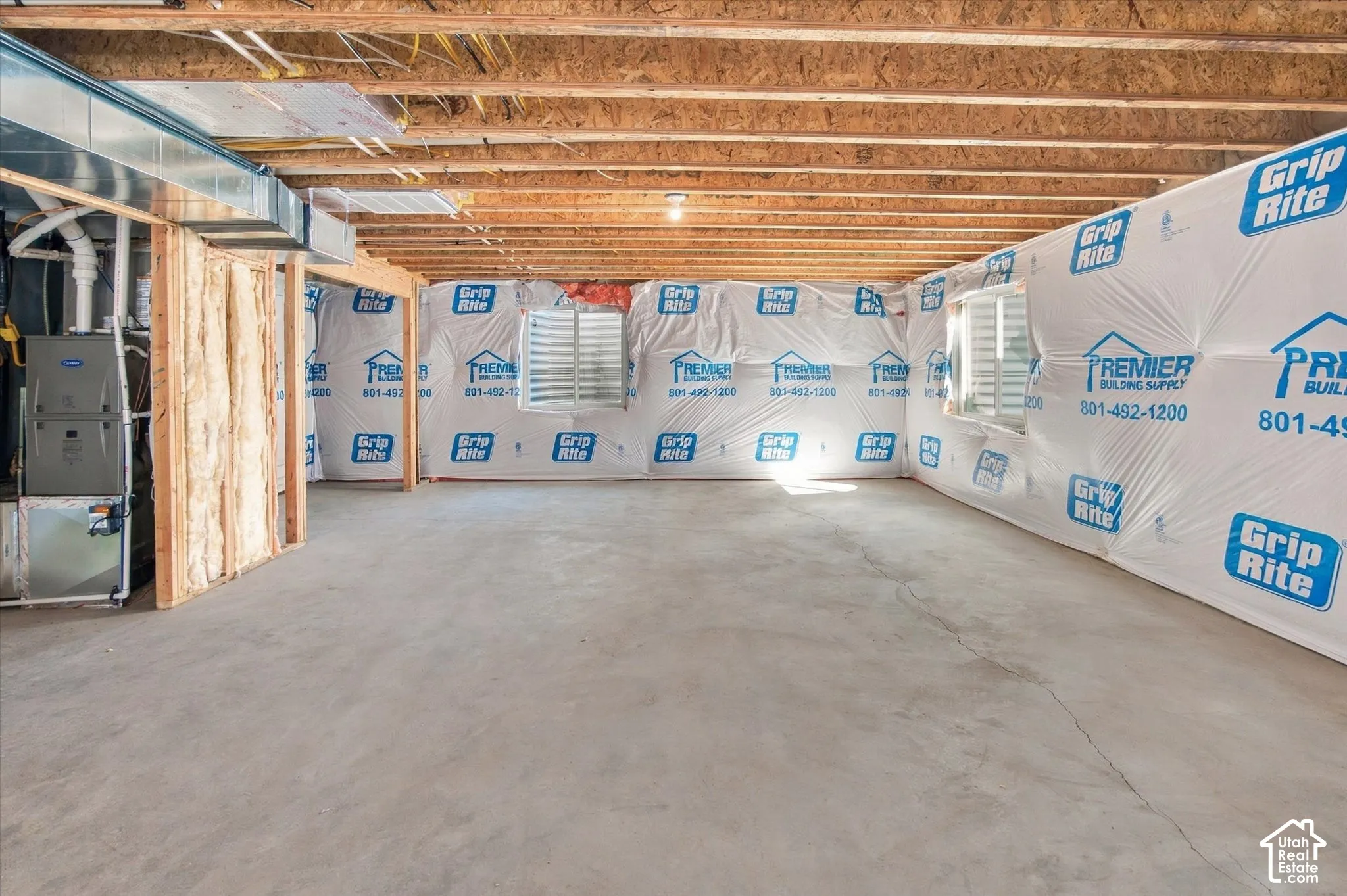 Unfinished basement featuring exposed wood joists, concrete flooring, and visible HVAC ductwork