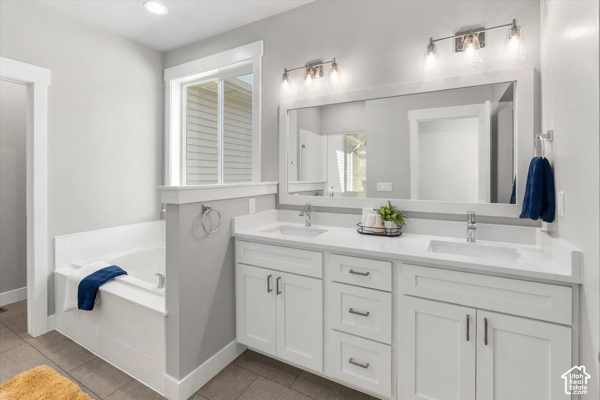 Dual vanity with white cabinetry, integrated sinks, and polished chrome hardware