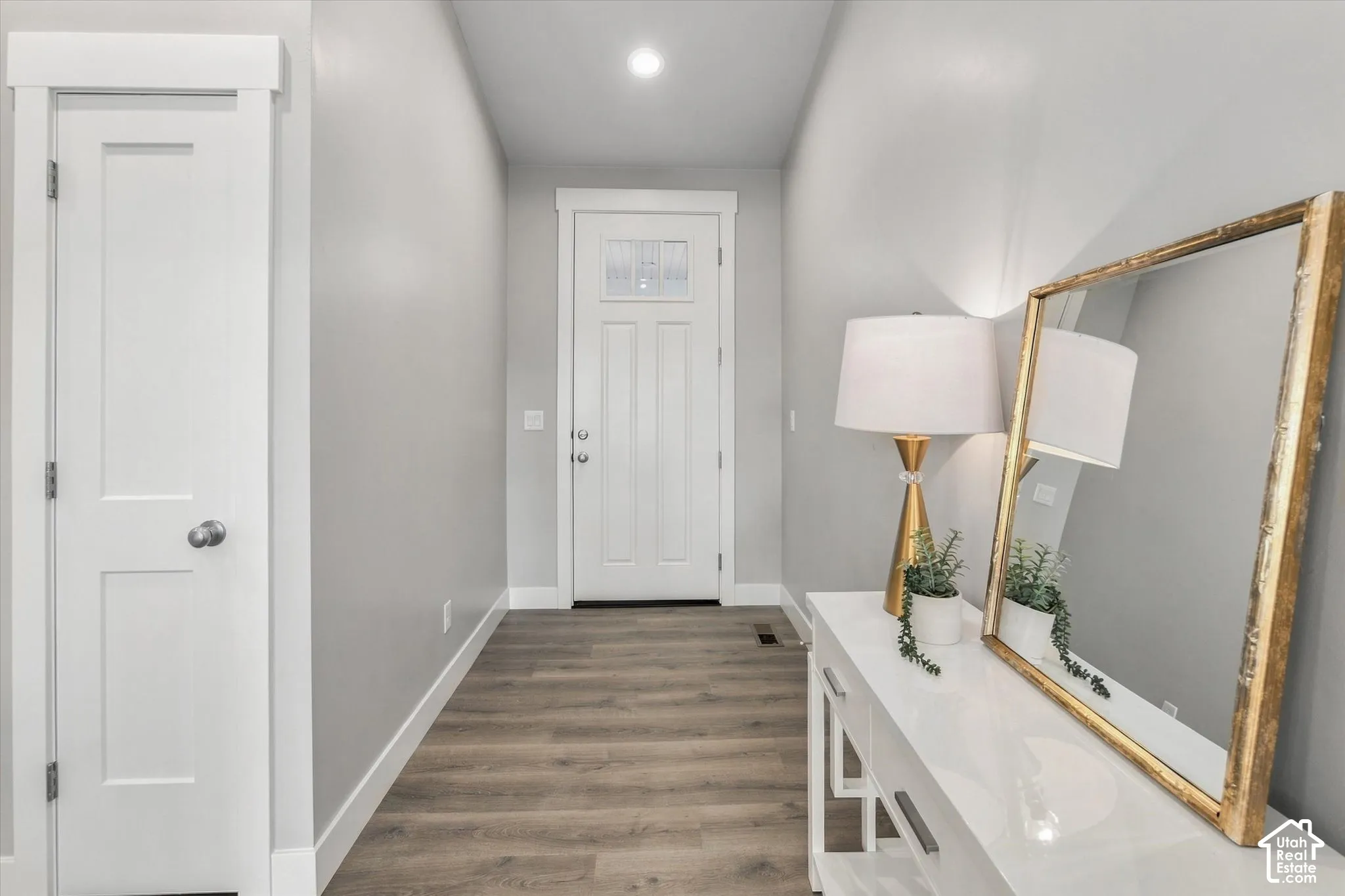 Entryway featuring wood-finish flooring, a white paneled door, and recessed lighting