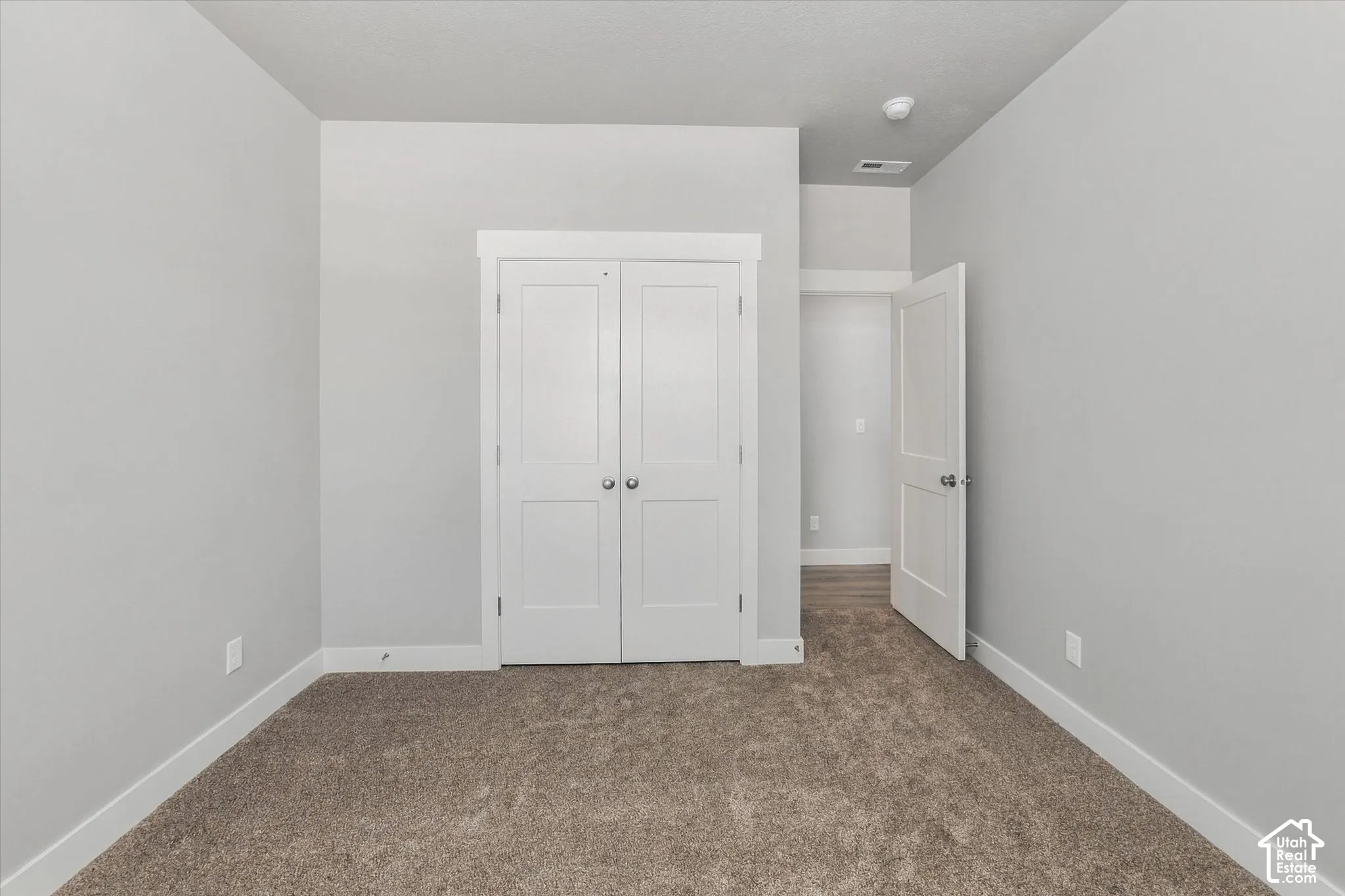 Neutral wall color, light-toned carpet, white trim, and white doors