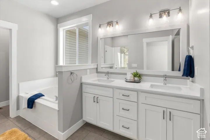Dual vanity with white cabinetry, integrated sinks, and polished chrome hardware