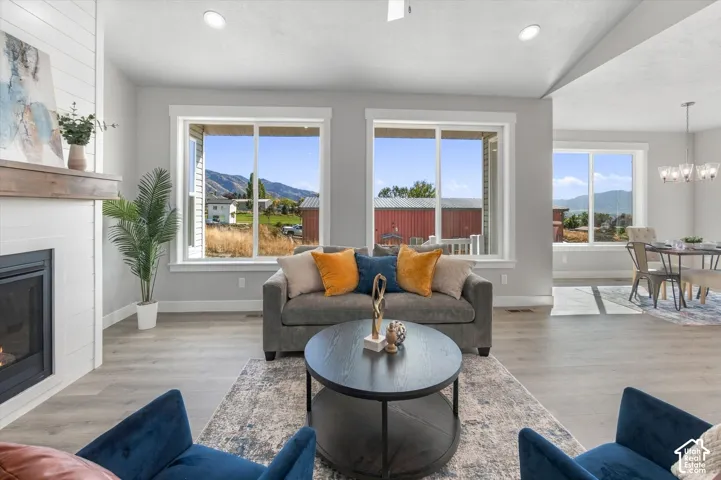 Spacious living area featuring wood-finish flooring, a fireplace with a wood mantle, and white shiplap accent wall