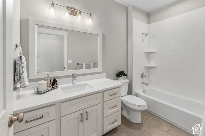 White vanity with rectangular sink, polished chrome faucet, and integrated storage