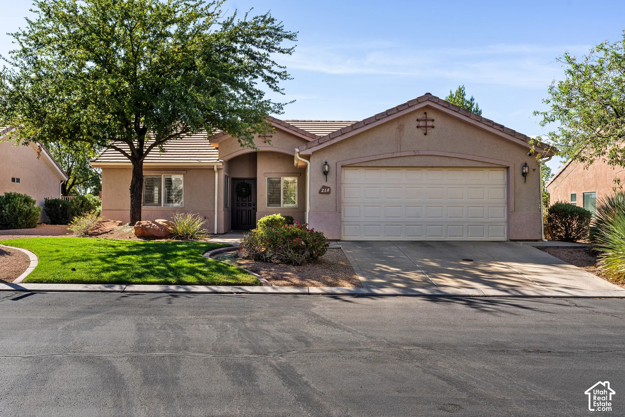 Single-story residence featuring a stucco exterior, attached two-car garage, and a concrete driveway