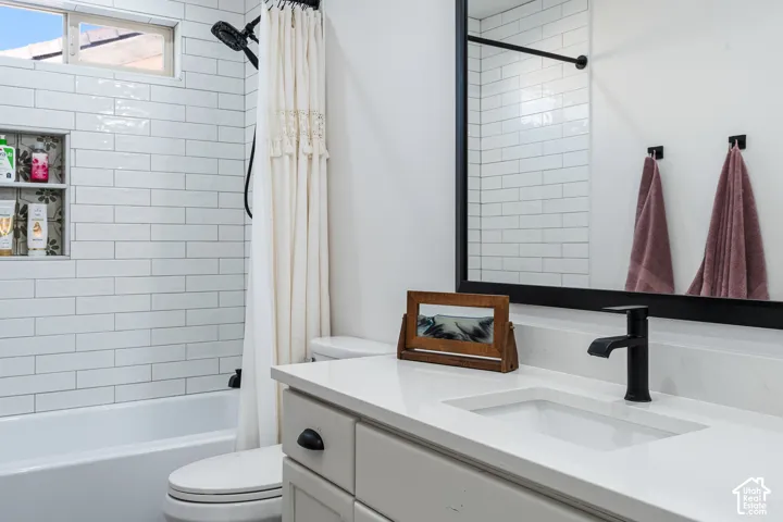 White subway tile shower surround with an integrated niche, a window, and a black showerhead