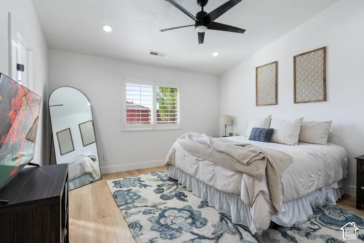 Recessed lighting, sloped ceiling, wood-finish flooring, window with plantation shutters, and a ceiling fan with integrated lighting