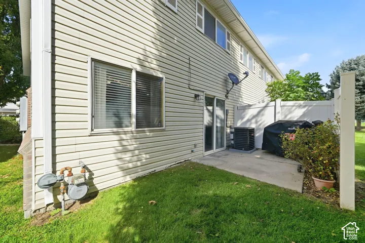 Rear exterior featuring siding, sliding glass door, and concrete patio