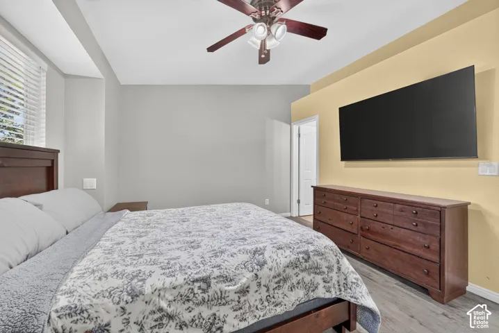 Hardwood-finish flooring, ceiling fan, and window with blinds