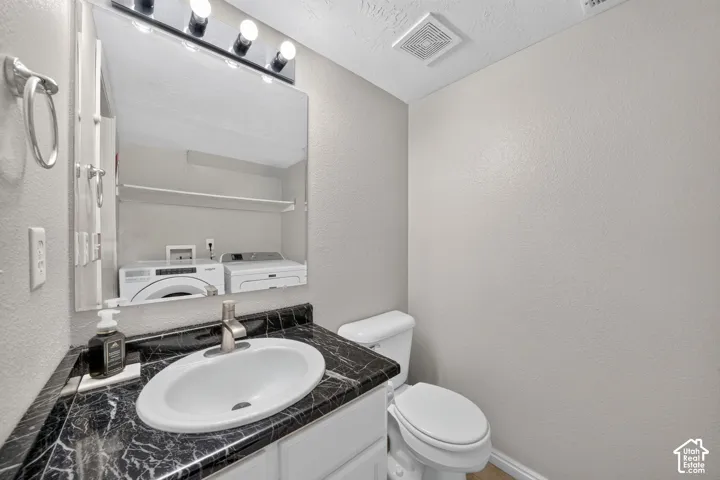 Vanity with a black patterned countertop, undermount sink, and brushed nickel faucet