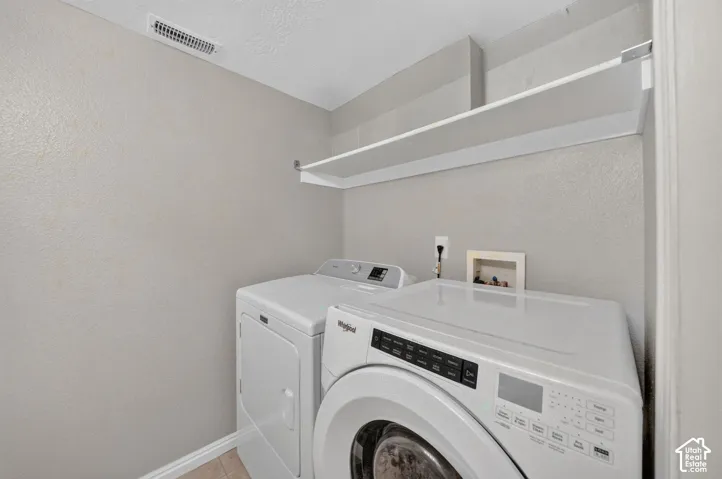 Dedicated laundry area with built-in shelving and light-toned walls