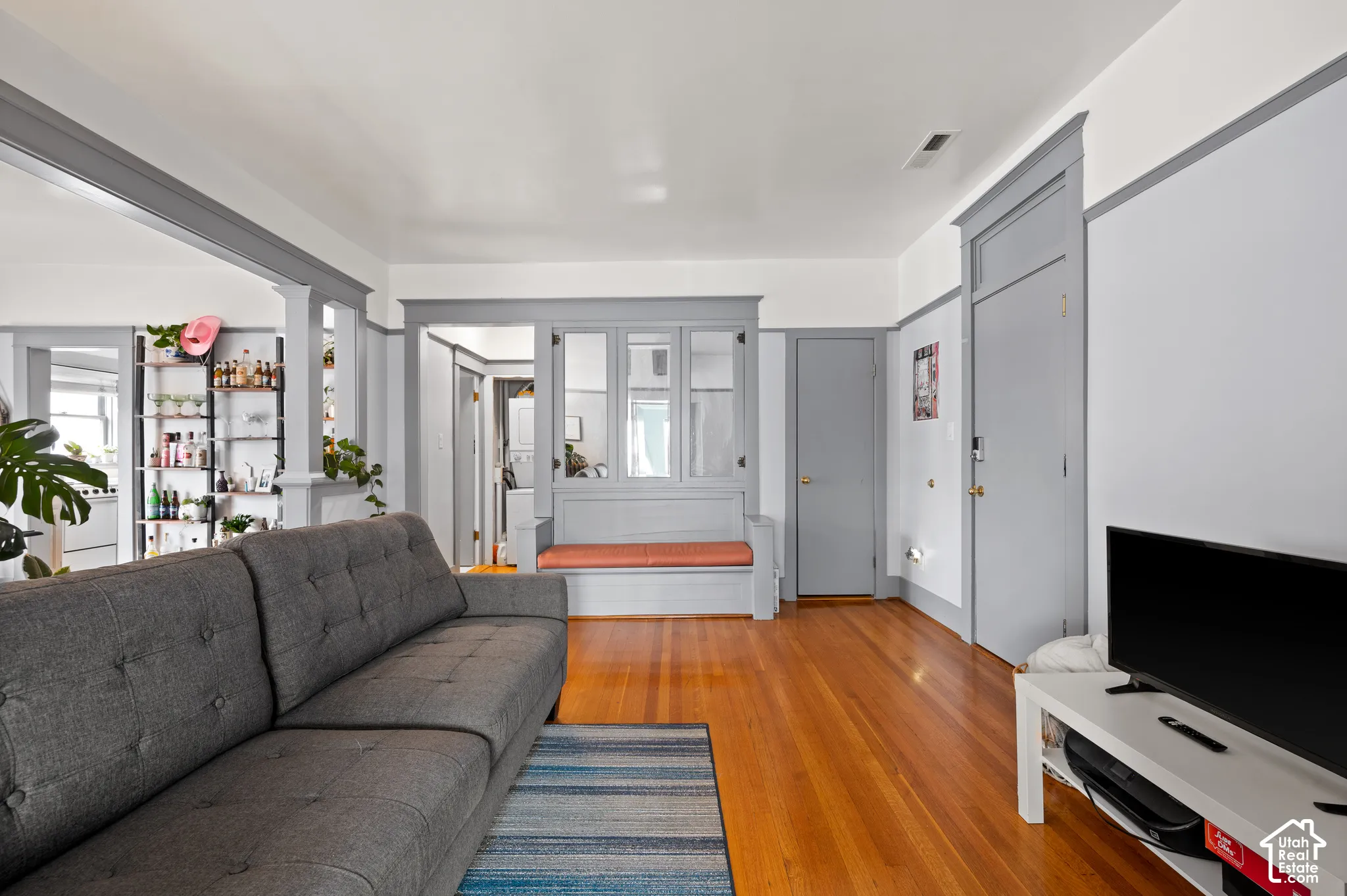 Wood-finish flooring throughout, featuring a built-in bench with framed windows