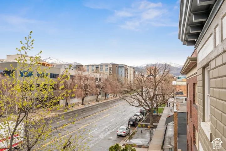 Cityscape with a prominent street, surrounding buildings, and distant snow-capped mountains