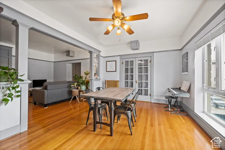 Hardwood flooring, painted trim and wall molding, high ceilings, and a ceiling fan with integrated lighting