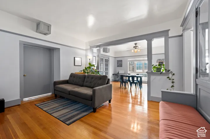 Hardwood flooring, painted trim and door frames, built-in half wall with column accents, recessed lighting, and a ceiling fan