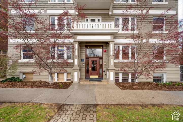Exterior building showcasing horizontal siding, multiple pane windows, and a prominent entry with a balcony
