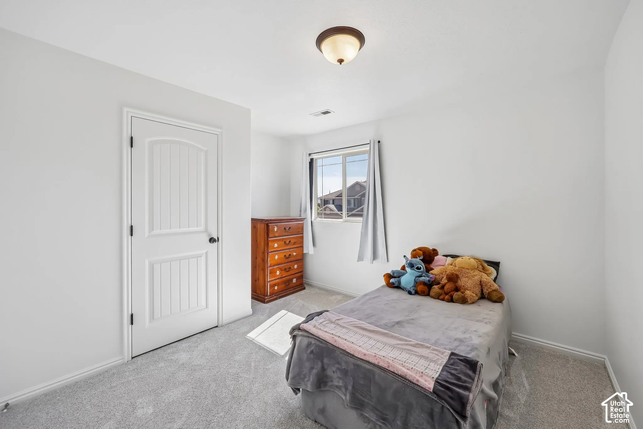 Soft gray carpeting, white walls, and a window with natural light