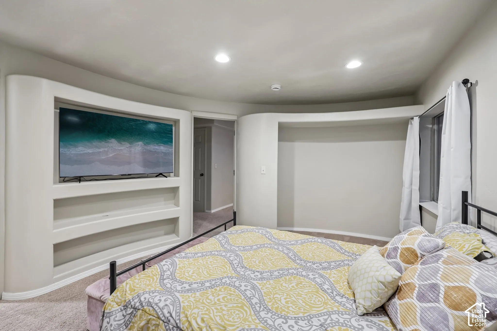 Built-in media niche with shelving, recessed lighting, and curved architectural wall details