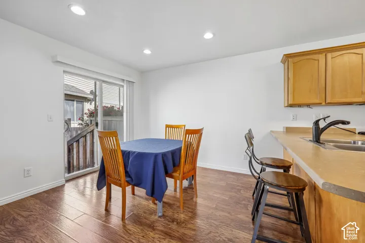 Recessed ceiling lighting, wood-finish flooring, sliding glass door, and a kitchen counter with an integrated sink