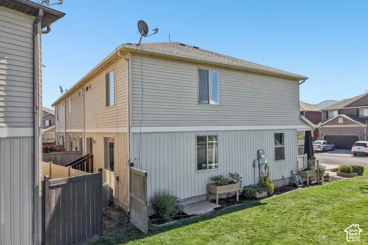 Two-story exterior featuring horizontal siding, multiple windows, and a landscaped yard