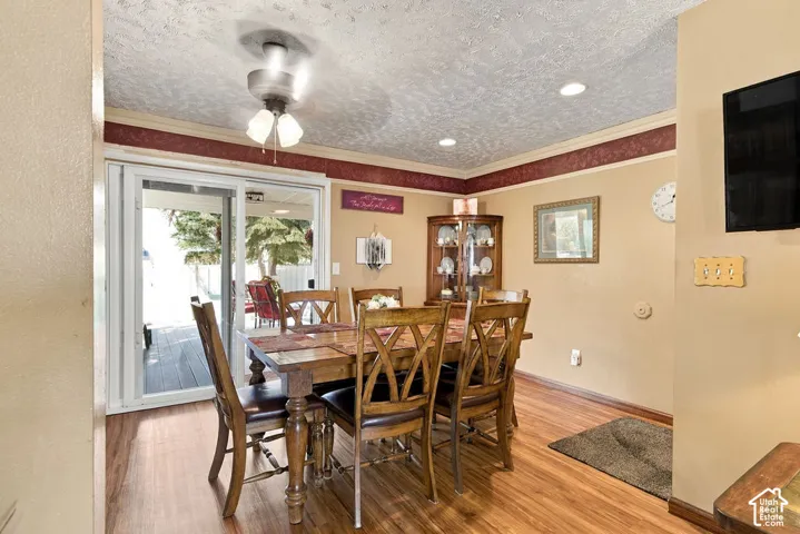 Wood-finish flooring, recessed lighting, ceiling fan light fixture, sliding glass door, and a corner built-in display cabinet