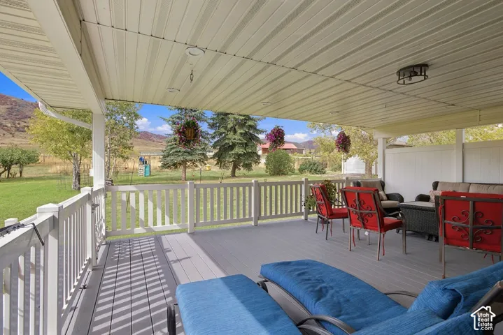 Covered outdoor deck with composite decking, white railing, and an overhead light fixture