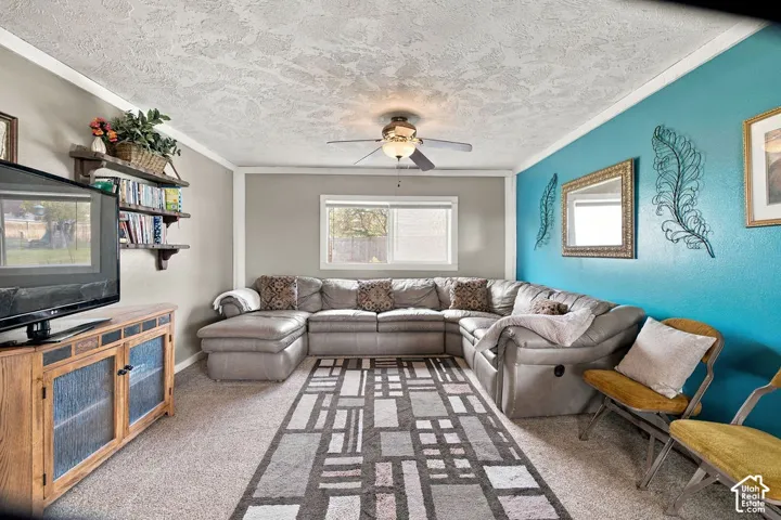 Couch with chaise lounge and recliners, wood-finish console with glass-front doors, built-in shelving, and ceiling fan