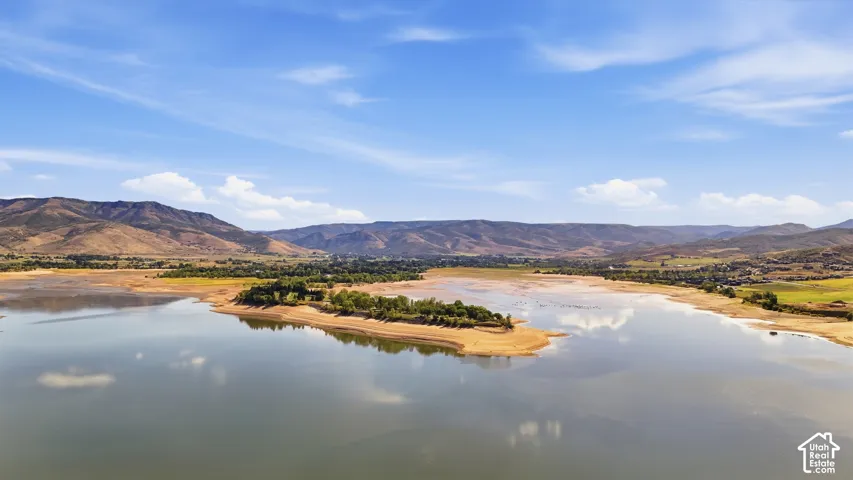 Expansive water feature bordered by natural land formations and distant mountains