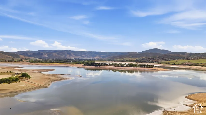 Expansive lake frontage with surrounding mountain range and clear skies